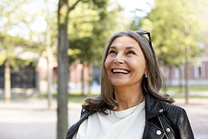 Woman with leather jacket and sunglasses walking outside