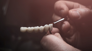 Lab technician painting replacement teeth