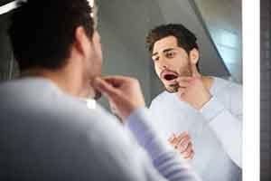 Patient in Springfield checking their dental implants in mirror