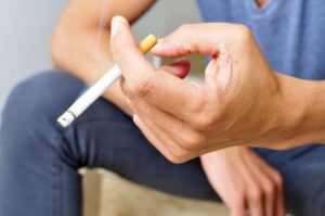 Close up of man holding a cigarette